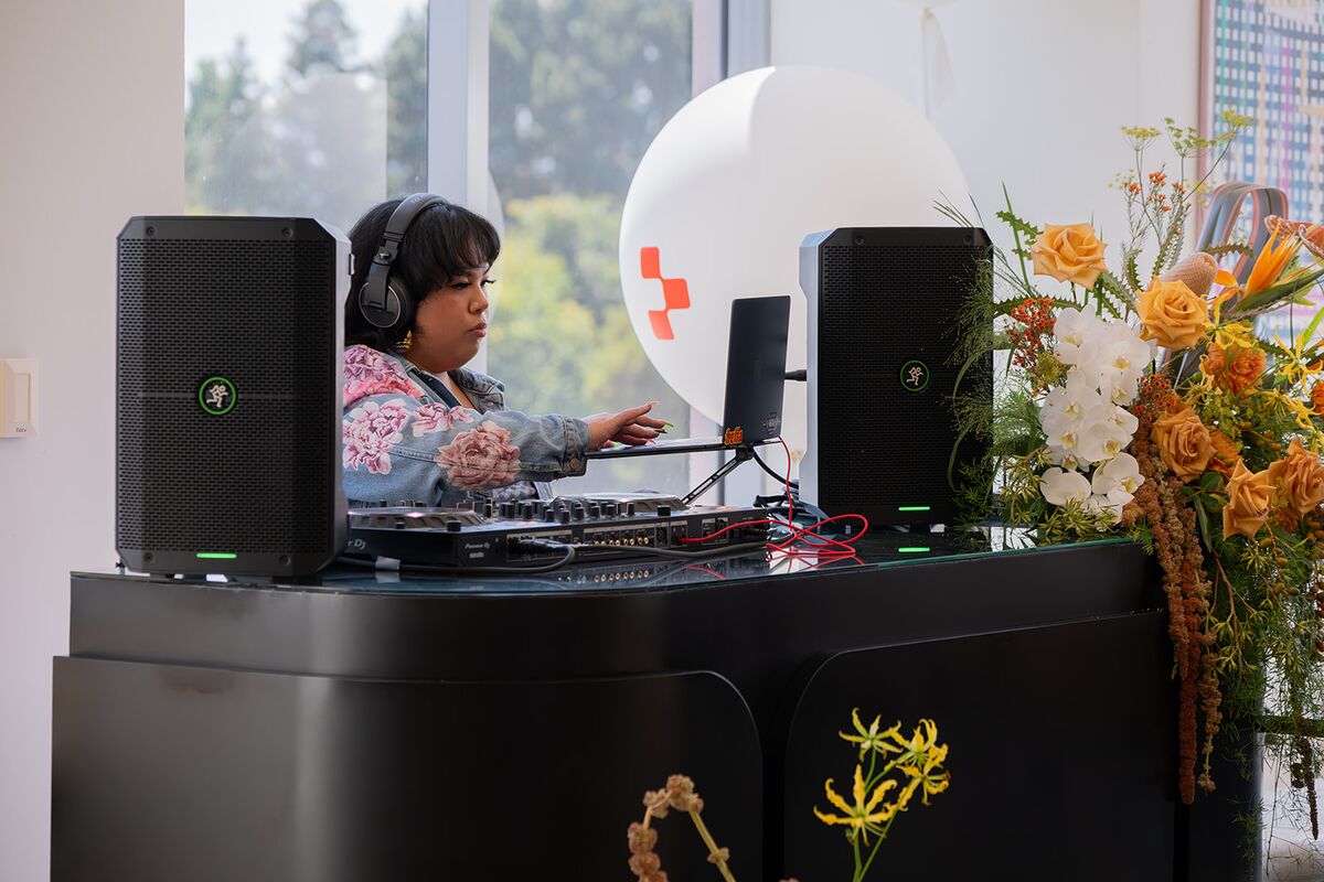 A teammate in headphones playing music at a window-side DJ booth