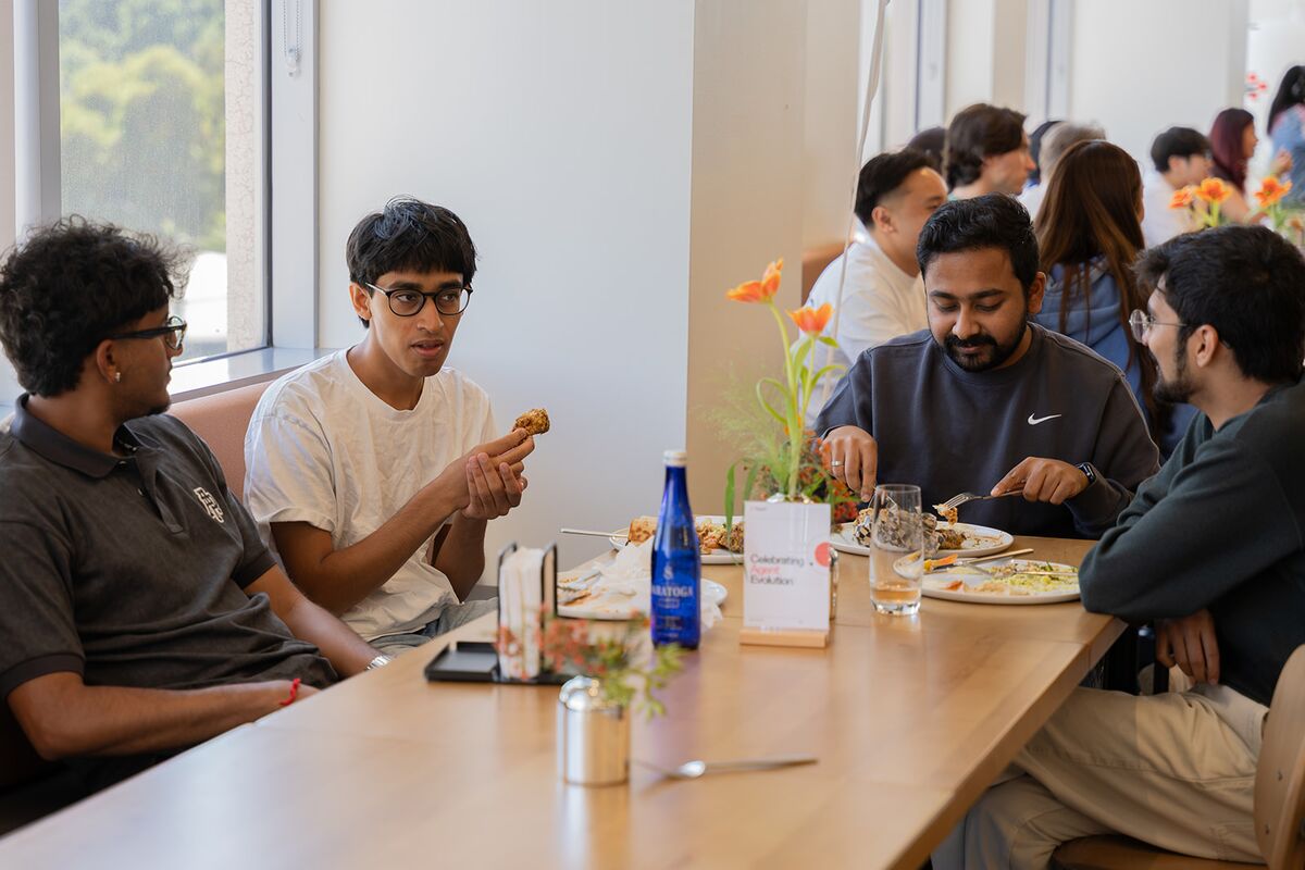 Teammates sharing lunch and conversation around a dining table