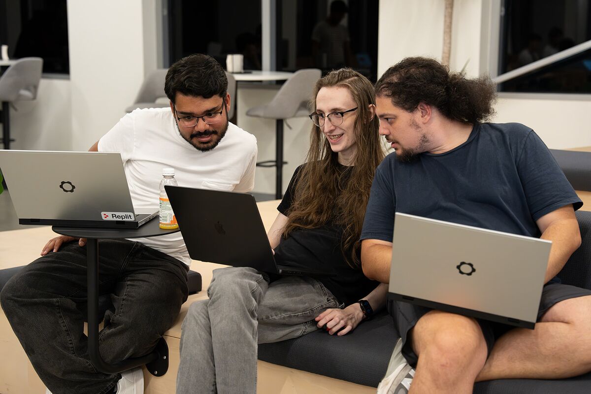 Three teammates working together on laptops in a lounge area