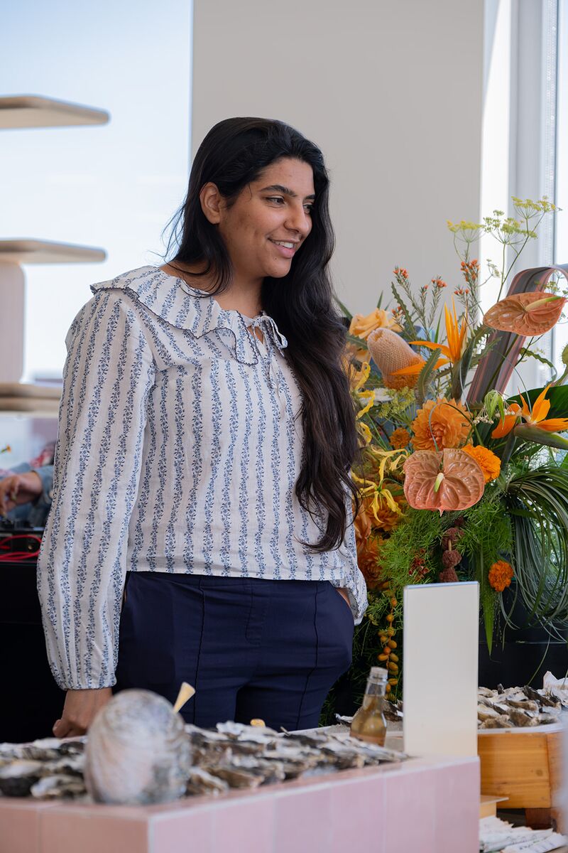 A teammate smiling beside a shared food spread and bright flowers