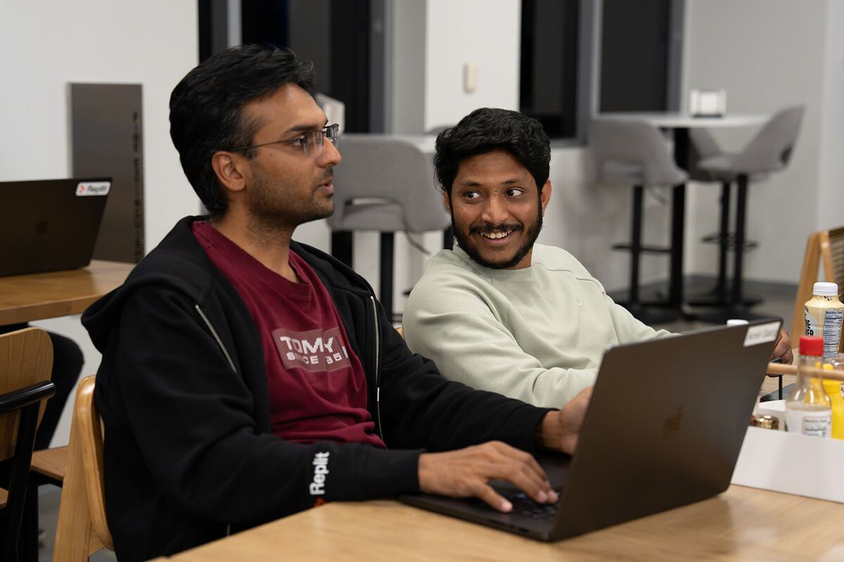 Two teammates working side by side and sharing a laugh