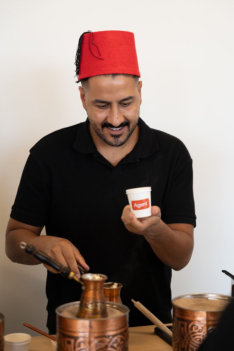 Event staff smiling while preparing Turkish coffee in copper pots