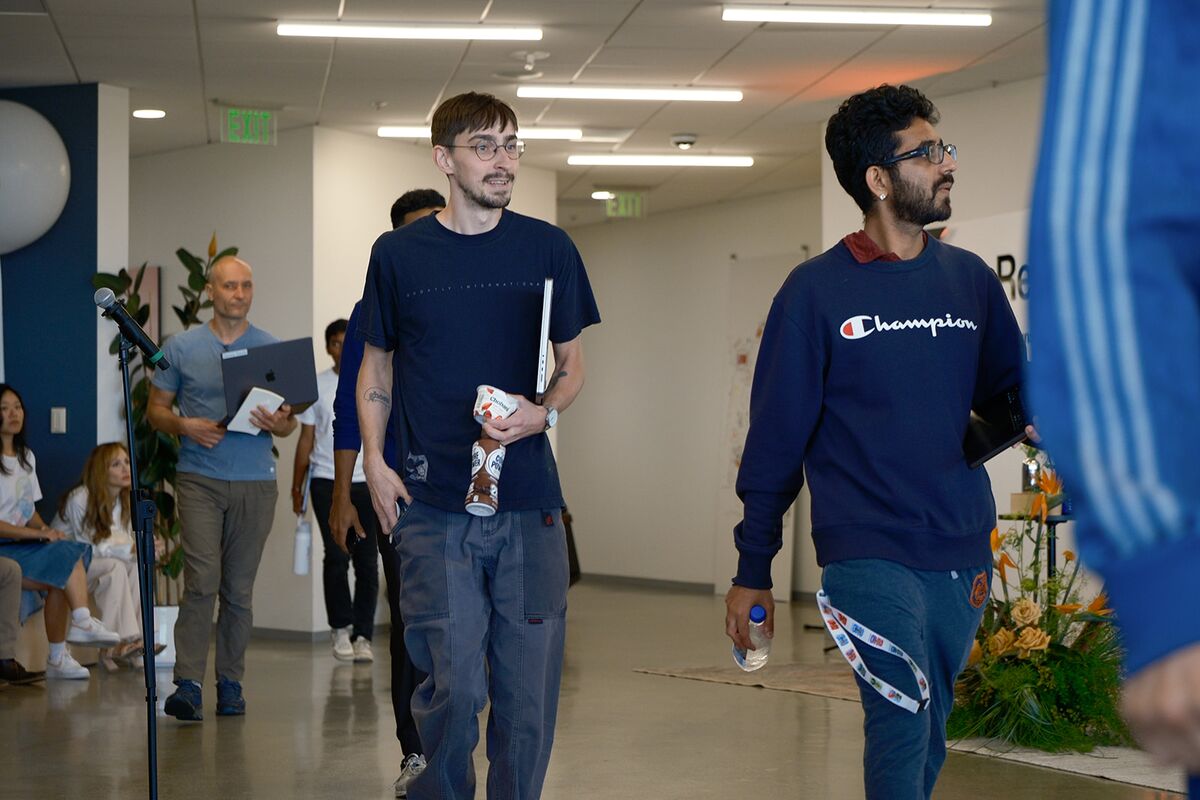 Teammates walking and chatting through the open office